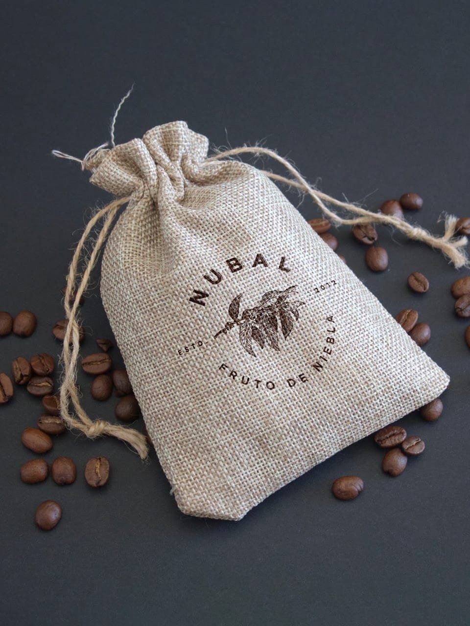 A cloth pouch with the Nubal seal and coffee beans