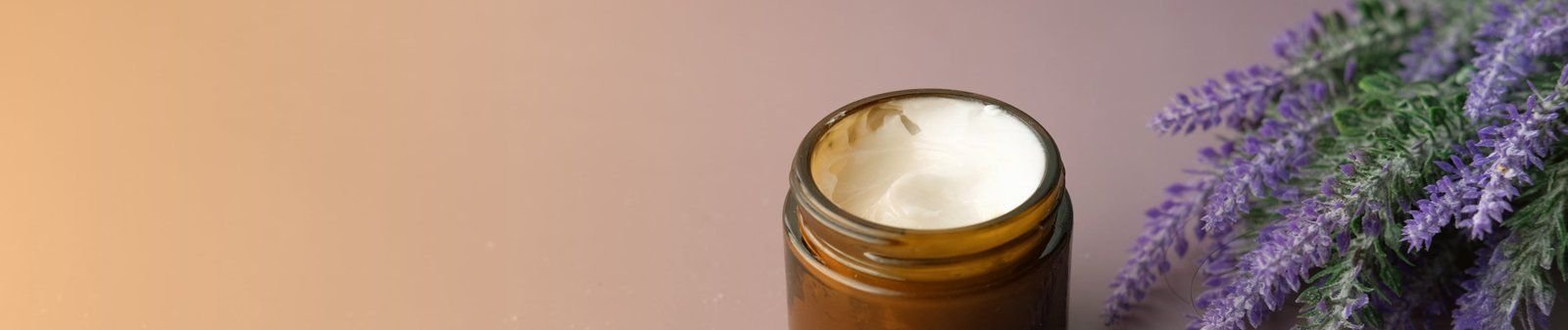 A jar of Juveness cream next to sprigs of lavender
